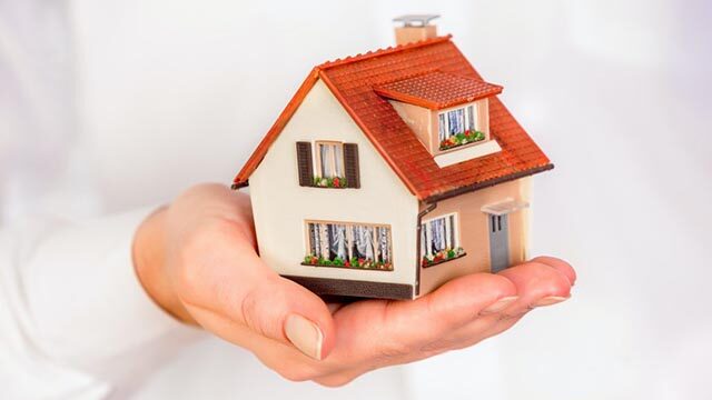 a-miniature-house-with-a-red-roof-being-held-in-a-persons-hand