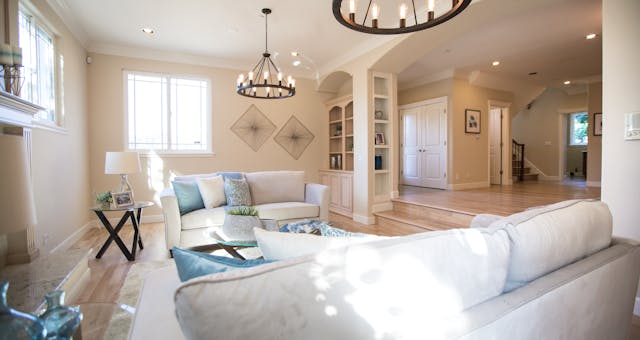 A living room with white furniture and a chandelier