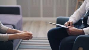 two people sitting with clipboard